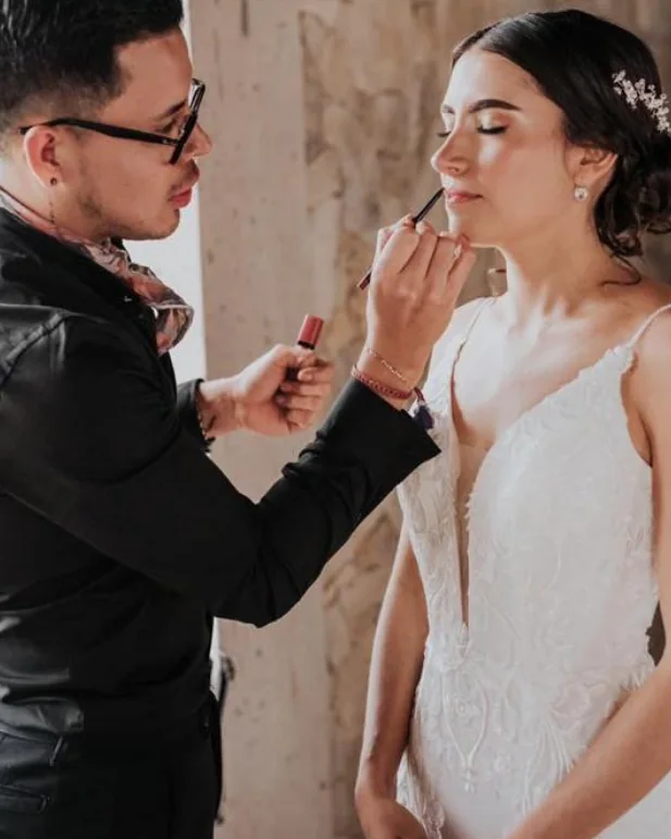 Enrique applying a bride's lip color before her ceremony.